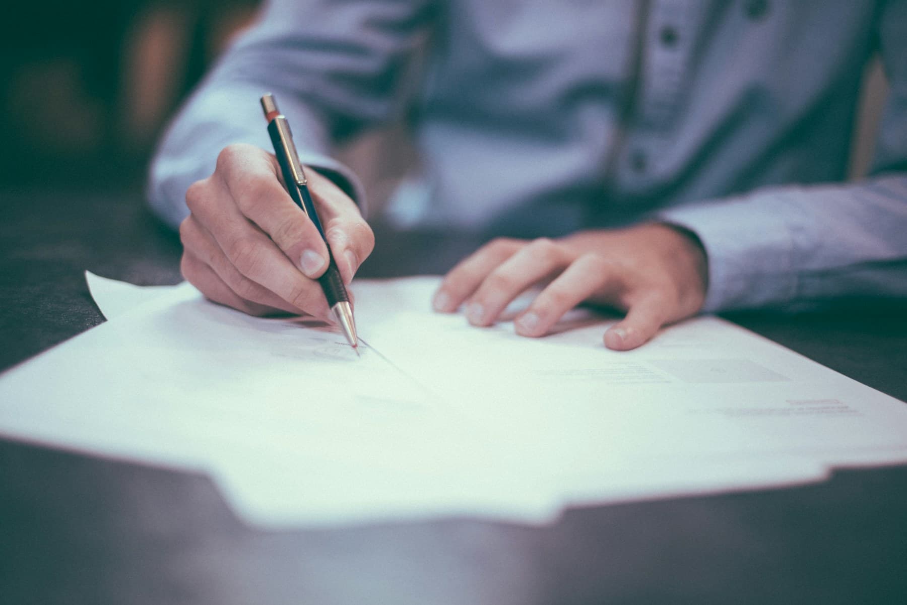 A person reviewing and signing an agreement